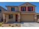Charming two-story home featuring a two-car garage, red shutters, and low-maintenance desert landscaping at 18351 W Patrick Ln, Surprise, AZ 85387