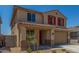 Charming two-story home featuring a two-car garage, red shutters, and desert landscaping at 18351 W Patrick Ln, Surprise, AZ 85387