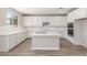 Charming kitchen with stainless steel appliances, center island, and white cabinets at 18351 W Patrick Ln, Surprise, AZ 85387