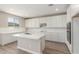 Bright kitchen features a large kitchen island and ample white cabinets at 18351 W Patrick Ln, Surprise, AZ 85387
