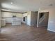 Spacious living room with wood-look tile, a staircase, recessed lighting, and a view of the modern kitchen at 18351 W Patrick Ln, Surprise, AZ 85387