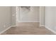 Spacious living room with light wood-look flooring, neutral walls, and white baseboards at 18351 W Patrick Ln, Surprise, AZ 85387