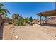 Desert backyard featuring a built-in BBQ, pizza oven, small pond, and mature landscaping at 18449 W Piedmont Rd, Goodyear, AZ 85338