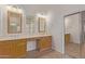 Bathroom with double vanity, framed mirrors, and sliding door to closet at 18449 W Piedmont Rd, Goodyear, AZ 85338