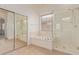 Bright bathroom with a glass shower, soaking tub, and tile flooring at 18449 W Piedmont Rd, Goodyear, AZ 85338