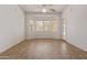 Open living room area with wood-look tile floors, bay window, and ceiling fan at 18449 W Piedmont Rd, Goodyear, AZ 85338