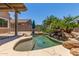 Backyard pool area with lush landscaping, rock features, and a serene waterfall creating a tranquil retreat at 18449 W Piedmont Rd, Goodyear, AZ 85338