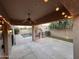View of a covered back patio with ceiling fan, string lights, and a gate surrounding the pool at 1865 E Locust Pl, Chandler, AZ 85286