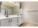 Bathroom with double sink vanity featuring white cabinets, dark hardware, and a large mirror at 1865 E Locust Pl, Chandler, AZ 85286