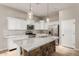 A bright kitchen features white cabinets, stainless steel appliances, and a granite island with a brick base at 1865 E Locust Pl, Chandler, AZ 85286
