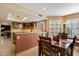 Open dining area with wood table near kitchen, shuttered windows, and tiled flooring at 18780 N 94Th Ave, Peoria, AZ 85382