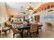Elegant dining area with chandelier lighting, tile floors, and open access to the living room at 18780 N 94Th Ave, Peoria, AZ 85382
