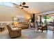 Comfortable living room featuring a ceiling fan, tile floors, and a sliding glass door to the patio at 18780 N 94Th Ave, Peoria, AZ 85382