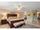 Comfortable bedroom with ceiling fan, large bed, and en-suite bathroom access at 18780 N 94Th Ave, Peoria, AZ 85382