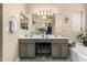 Bathroom featuring double sinks, decorative vanity lighting, and closet access at 20038 N 38Th Ln, Glendale, AZ 85308