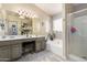 Bright bathroom with a double vanity, tub, and walk-in shower at 20038 N 38Th Ln, Glendale, AZ 85308