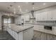 Modern kitchen featuring a large island, stainless steel hood, and white cabinetry at 20452 E Appaloosa Dr, Queen Creek, AZ 85142