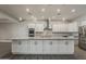 Bright kitchen featuring white cabinets, marble countertops, stainless steel appliances and a large island at 20452 E Appaloosa Dr, Queen Creek, AZ 85142