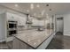 Bright kitchen featuring white cabinets, marble countertops, stainless steel appliances and a large island at 20452 E Appaloosa Dr, Queen Creek, AZ 85142