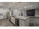 Kitchen view of an island with marble countertop, wine fridge, stainless steel appliances and access to dining area at 20452 E Appaloosa Dr, Queen Creek, AZ 85142