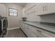 Spacious laundry room with extensive gray cabinetry, marble countertops, and a modern washer and dryer at 20452 E Appaloosa Dr, Queen Creek, AZ 85142