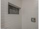 Close up detail of the modern tiled shower with wave texture design and built in shelf at 20452 E Appaloosa Dr, Queen Creek, AZ 85142