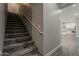 Carpeted stairway leading to a bright, open floor plan with a glimpse of the modern kitchen at 20452 E Appaloosa Dr, Queen Creek, AZ 85142