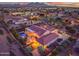 Expansive aerial view showcasing a private backyard pool and city lights at dusk at 24695 S 195Th Way, Queen Creek, AZ 85142
