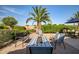 Inviting outdoor space with a decorative fire pit, manicured landscaping, and a mature palm tree at 24695 S 195Th Way, Queen Creek, AZ 85142