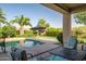 Charming backyard view from covered patio, featuring a pool, putting green and lush landscaping at 24695 S 195Th Way, Queen Creek, AZ 85142