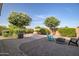 Private backyard oasis with a cozy fire pit, comfortable seating, and beautiful flowering trees at 24695 S 195Th Way, Queen Creek, AZ 85142