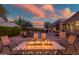 Outdoor living space with a fire pit, patio, seating, and pool surrounded by beautiful desert landscaping at 24695 S 195Th Way, Queen Creek, AZ 85142