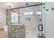 Modern bathroom featuring glass shower with unique tile work, a tub and large windows at 24695 S 195Th Way, Queen Creek, AZ 85142
