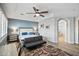 Well-lit bedroom featuring a bed, sitting area, ceiling fan, and stylish decor at 24695 S 195Th Way, Queen Creek, AZ 85142