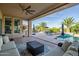 Relaxing covered patio with ceiling fan and furniture overlooking the inviting pool and manicured backyard at 24695 S 195Th Way, Queen Creek, AZ 85142