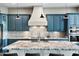 Stylish kitchen featuring a large island with granite countertops, custom cabinets, and stainless steel appliances at 24695 S 195Th Way, Queen Creek, AZ 85142