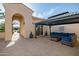 Inviting covered patio with stylish blue sofa and hardscaped flooring, perfect for outdoor relaxation at 24695 S 195Th Way, Queen Creek, AZ 85142