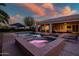Inviting backyard pool and spa area with covered patio, seating, and beautifully lit at twilight at 24695 S 195Th Way, Queen Creek, AZ 85142