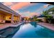 A serene outdoor pool setting with covered seating and manicured landscaping at 24695 S 195Th Way, Queen Creek, AZ 85142