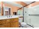 Bright bathroom with a shower featuring glass doors and a vanity with wooden cabinets at 25840 W Whyman St, Buckeye, AZ 85326