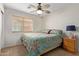 Well-lit bedroom featuring a ceiling fan, window with blinds, and neutral carpet at 25840 W Whyman St, Buckeye, AZ 85326