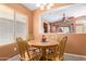 Cozy dining area featuring a round wooden table, chairs and pass through to the living room at 25840 W Whyman St, Buckeye, AZ 85326