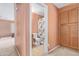 Hallway view to bathroom showing wooden cabinets and neutral colors at 25840 W Whyman St, Buckeye, AZ 85326