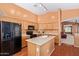 Kitchen featuring modern appliances, light wood cabinets, island with sink and breakfast bar seating at 25840 W Whyman St, Buckeye, AZ 85326