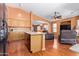 Open-concept living room featuring wood floors, kitchen, and comfortable seating at 25840 W Whyman St, Buckeye, AZ 85326