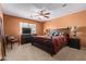 Comfortable main bedroom with a fan, dark wood furnishings, and natural light at 25840 W Whyman St, Buckeye, AZ 85326