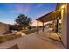 Beautiful backyard with a covered patio, a pool, and lush landscaping at twilight at 26204 S Washington St, Chandler, AZ 85249