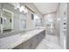 Bathroom featuring double sinks, granite counters, large mirrors and an elegantly tiled shower stall at 26204 S Washington St, Chandler, AZ 85249