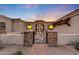 Home's front entrance featuring a courtyard, desert landscaping, and ornate metal security gate at 26204 S Washington St, Chandler, AZ 85249