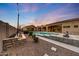 An outdoor pool in the backyard with covered patios at dusk at 26204 S Washington St, Chandler, AZ 85249